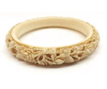 An early 20th Century Carved Ivory/Bone Bangle, decorated mainly with foliage, 4” diameter