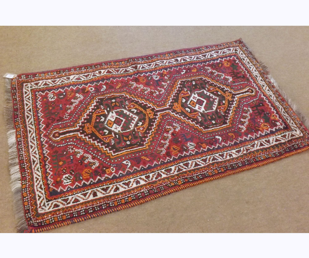 A Caucasian Wool Prayer Rug, central panel of two interlinked lozenges, mainly red and beige