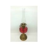 A Victorian Brass Oil Lamp with cranberry facetted font, 24” high