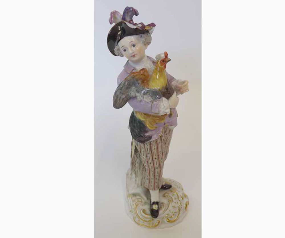 A Meissen Figure of a young dandy with a cockerel, wearing a plumed hat, further painted