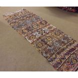 A Kilim Runner, decorated with parallel panels of geometric lozenges and designs, on a multi