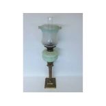 A Brass Corinthian Column Oil Lamp with scroll moulded pale green glass font and later green-