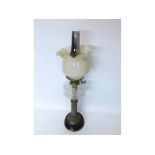 A Victorian and later Oil Lamp, crimped opaque floral moulded shade over a clear font, raised on