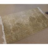 A late 20th Century Small Rug with single gull border, floral designs on a mainly beige/ochre field,