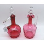 Mixed lot: two Victorian Cranberry and clear glass Decanters of varying designs, both fitted with