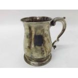 George II Silver Tankard of circular baluster form, fitted with scroll handle, raised on a stepped