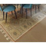 A decorative Wool Carpet, central panel of geometric lozenges mainly iron red, pale mauve and