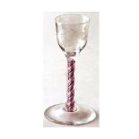 An 18th Century Wine Glass with engraved bowl, raised on a coloured air-twist stem terminating in