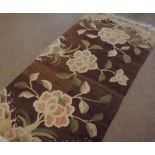 A Floral Decorated Wool Rug, panels of flowering foliage mainly brown and ochre field, 6’3” x 2’1”