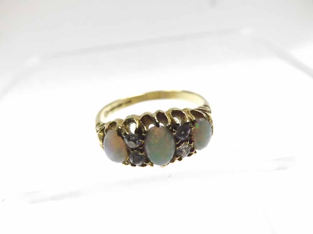 Early 20th Century hallmarked 18ct Gold Ring, claw set with three oval Opals, interspersed by four