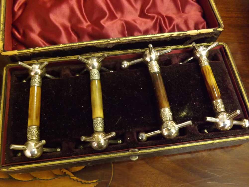 A cased set of four Silver Plate Mounted X-shaped Knife Rests, case 10” long