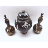 A Japanese famille noir composite Garniture, comprising a lidded jar and two similar covered