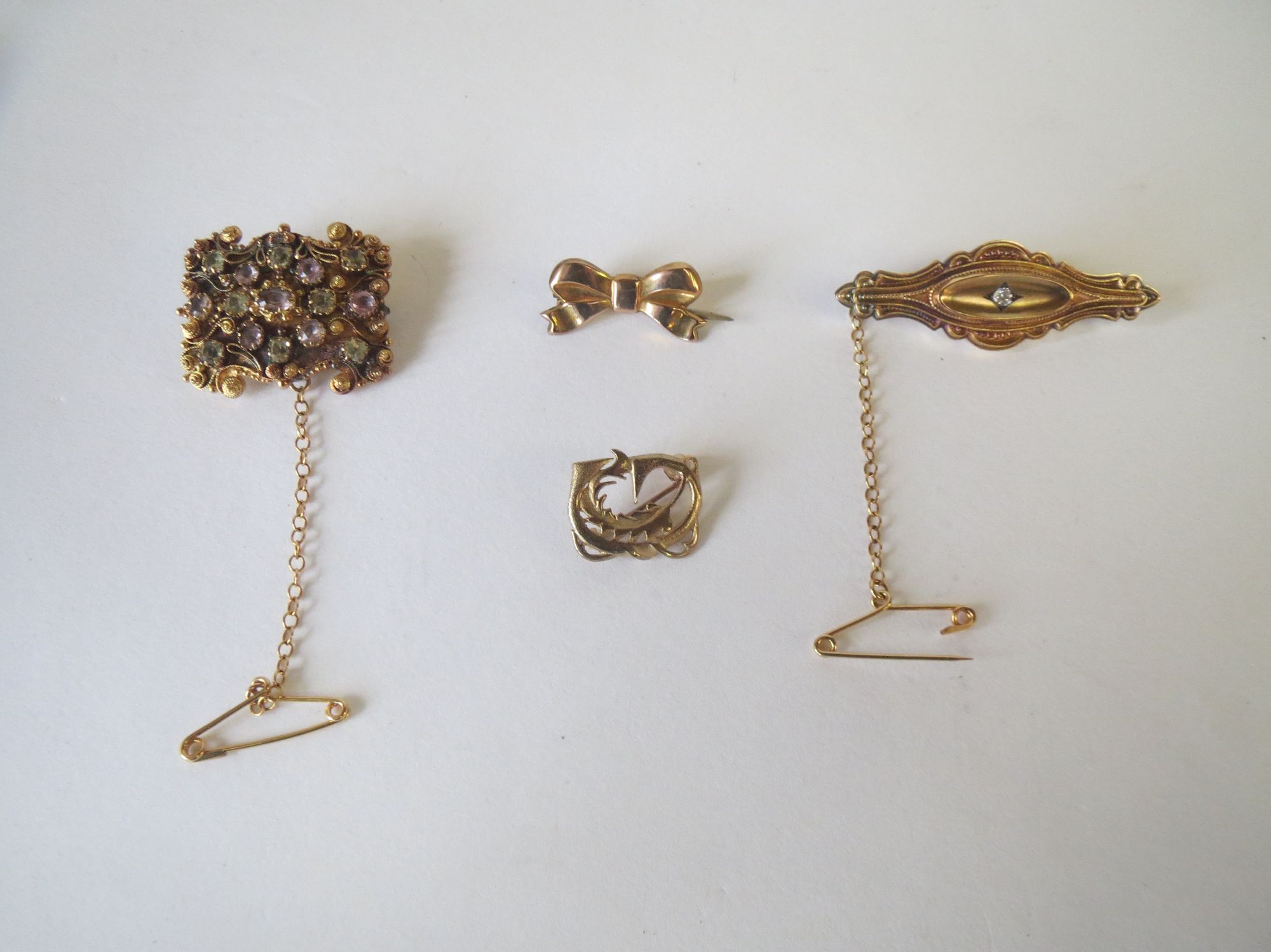 Four gold metal brooches. 12.5g