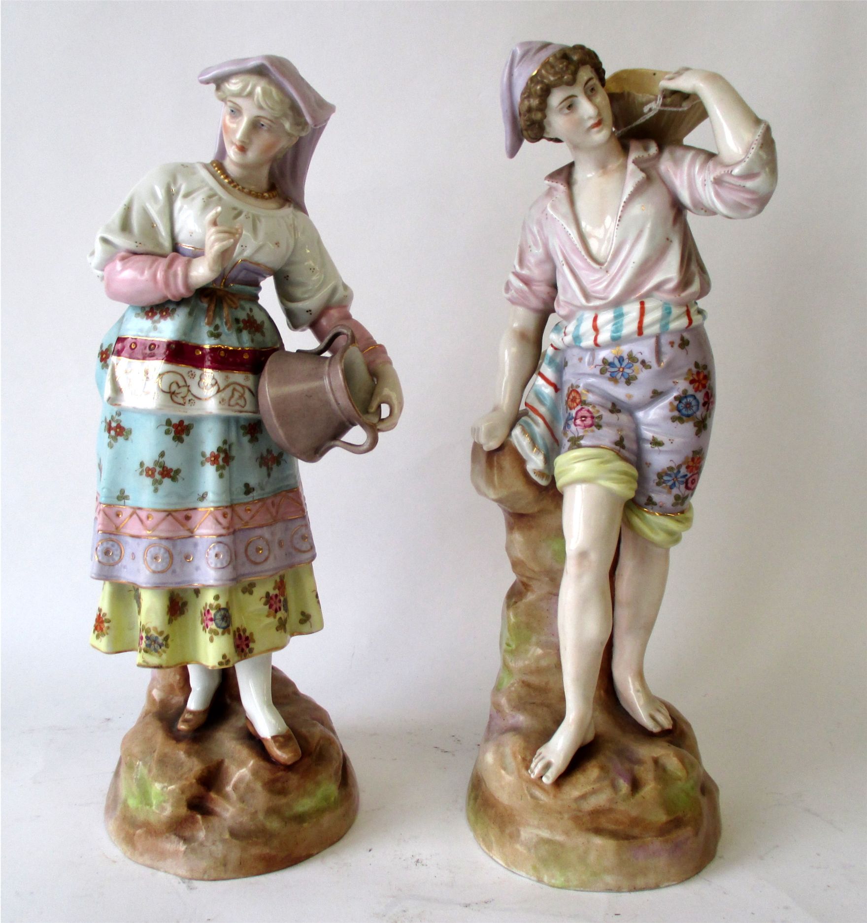 Pair continental figurines of a boy and a girl carrying vessels 33 cm H Condition: both good .