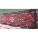 Turkish style C20th runner, decorated with geometric patterns to a red ground 285 cm x 84 cm