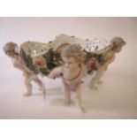 Pierced porcelain oval encrusted basket on 4 cherub supports 31 cm L Condition: good . rubbing to