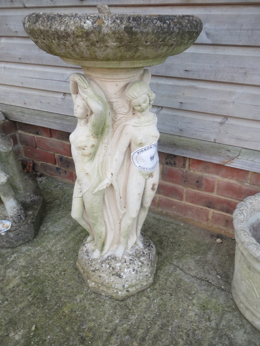 Weathered stone bird bath, the base depicting the "Three Graces" Condition: weathered