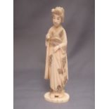 Early C20th Japanese carved ivory okimono of a lady, her robes with engraved and stained