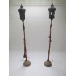 Pair Venetian Gondola lanterns supported on wooden shafts and two circular stones bases, 215cm H