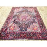 Large decorative rug with all over geometric pattern and stylised borders in reds, blues, cream