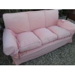 Early C20th three seater sofa with pink loose cover