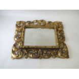 Carved gilt wood Florentine framed wall mirror, the oblong bevelled plate 36 cm x 27 cm