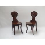 A pair of Regency mahogany hall chairs on reeded splayed feet