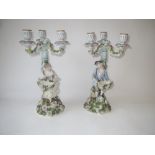 Pair of German porcelain figural three branch candelabra bearing blue cross marks to base 38H