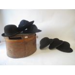 Four assorted black felt bowler hats, and a Trilby contained in a vintage hat box