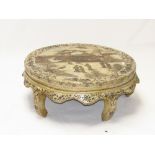 A Chinese circular white/cream painted circular low table carved with figures, cranes, pagoda on