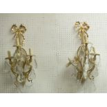 Pair of bronze and crystal three light wall sconces with female heads and cut prism drops