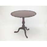 George III mahogany tilt top table with scroll and shell border on a central pedestal to tripod