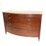 A Regency mahogany bowfront chest of three drawers flanked by reeded and foliate carved pilasters on