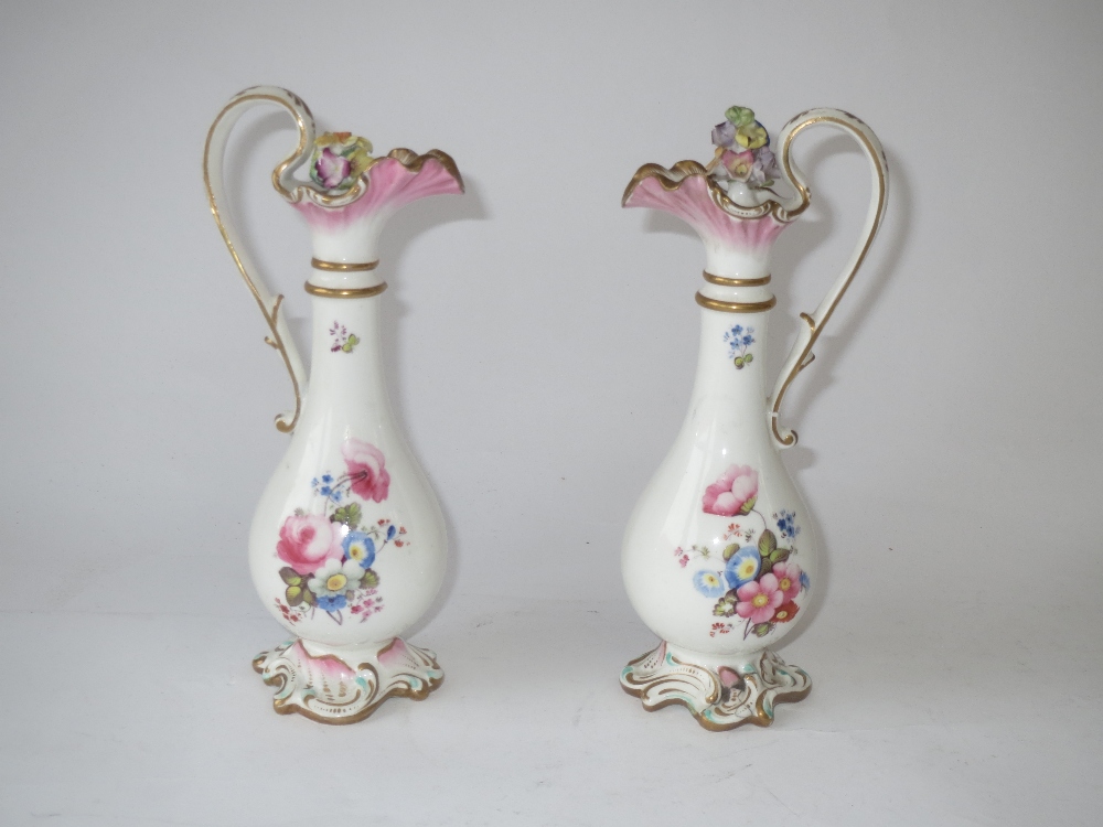 Pair of C19th porcelain ewer shaped oil and vinegar bottles painted with flowers on rococo style