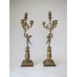 Pair of French Empire triple light gilt metal candelabra, the lights supported by winged cherubs