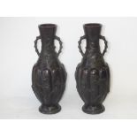 Pair of Japanese bronze twin handled vases, decorated in raised relief, 38cm high