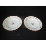 Pair of Chinese porcelain soup plates with floral sprigs in iron red and gilt, 23 cm dia