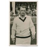 Don Bradman. Excellent mono postcard of a youthful Bradman, three quarter length, walking on to