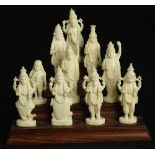 Ten (10) Indian Carved Ivory Deity Figures on Stepped Wood Base. Unsigned. Good Condition or Better.