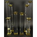 Charles Hollis Jones Eight (8) Piece Suite of Pedestal Style, Beveled Lucite and Brass Candlesticks.