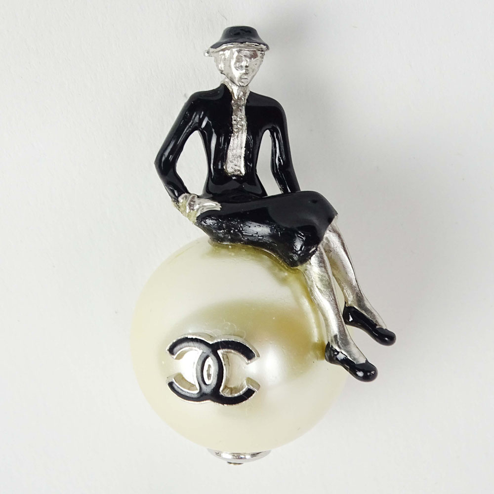 Chanel, Made in France Faux Pearl Brooch with an Enameled Seated Coco Chanel Figure. Signed. Surface