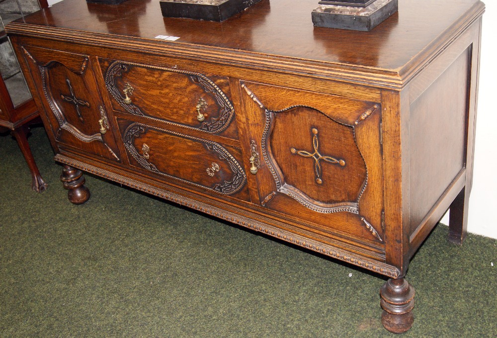 An oak two-drawer, two-door carved sideboard