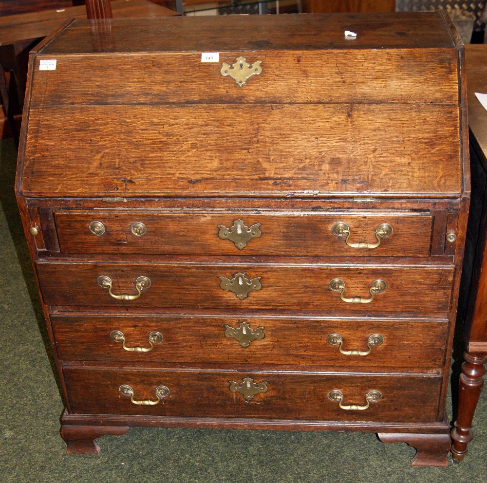 Georgian oak fall-front bureau with fitted interior above four long drawers, raised on bracket feet