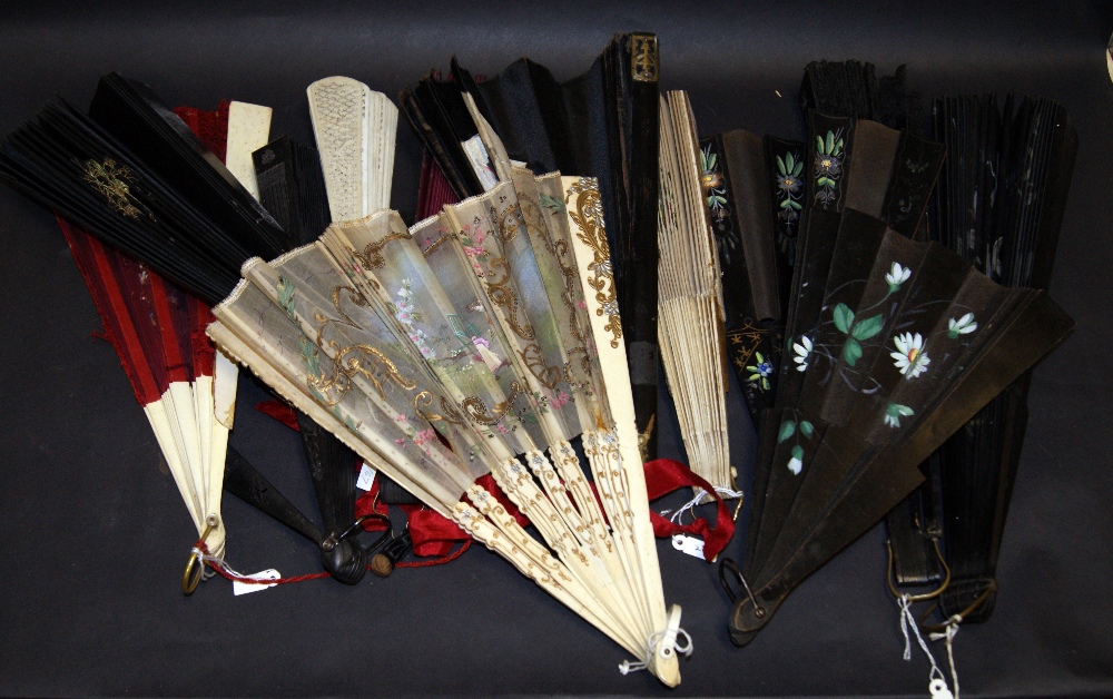 A selection of hand fans, including two Victorian black silk hand fans, one with an applied painted