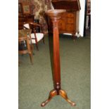 A Mahogany torchère stand, the column supported on a tripod base and having carved acanthus leaf