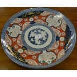 An early 19th century Japanese ceramic charger, colours from the Imari palette, with gilt