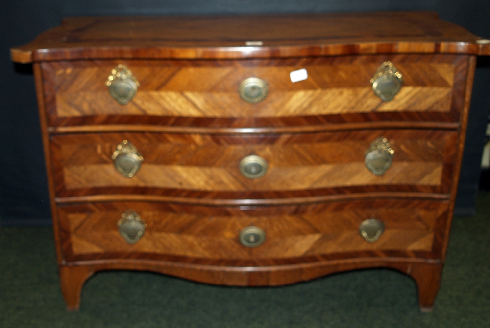 An 18th century Flemish oak and mahogany commode chest of three serpentine-fronted drawers,