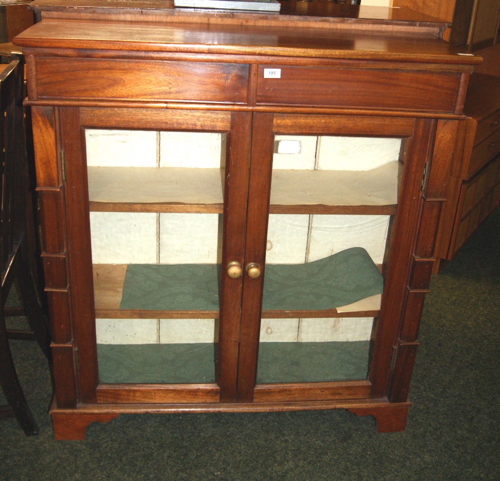 A Victorian mahogany two-door glazed bookcase with unusual shaped pilasters and two shelves