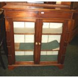 A Victorian mahogany two-door glazed bookcase with unusual shaped pilasters and two shelves