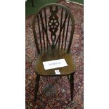 Set of four wheel-back pine dining chairs